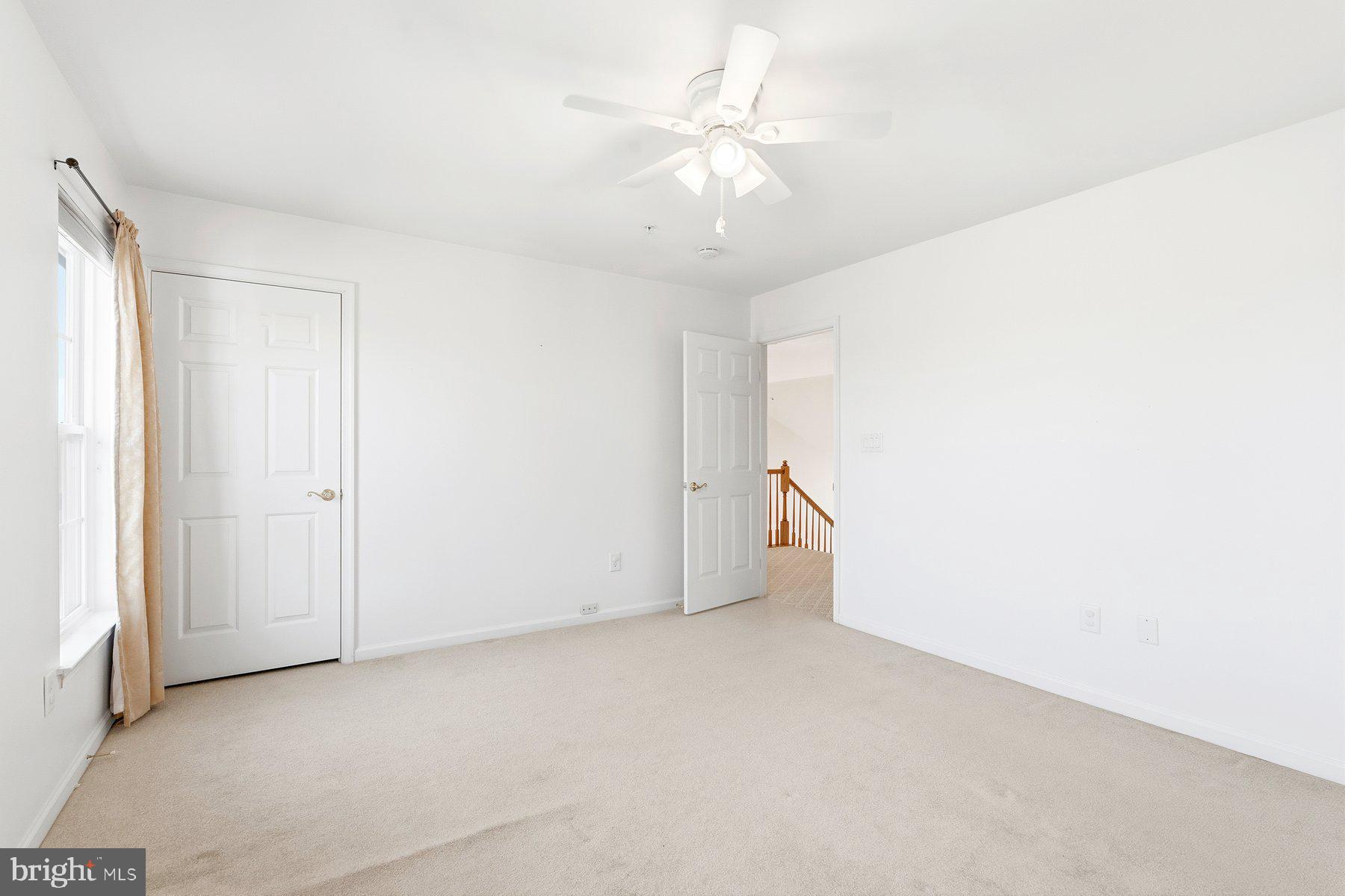 8330 Meadowsweet Road, Unit 8330 Pikesville, MD 21208 - Photo 28 of 55 an empty room with a ceiling fan and a window