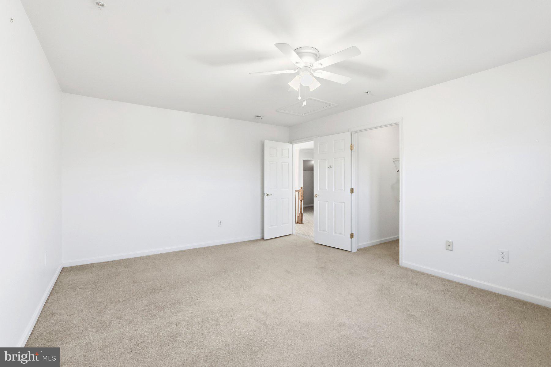 8330 Meadowsweet Road, Unit 8330 Pikesville, MD 21208 - Photo 30 of 55 an empty room with a chandelier fan and windows
