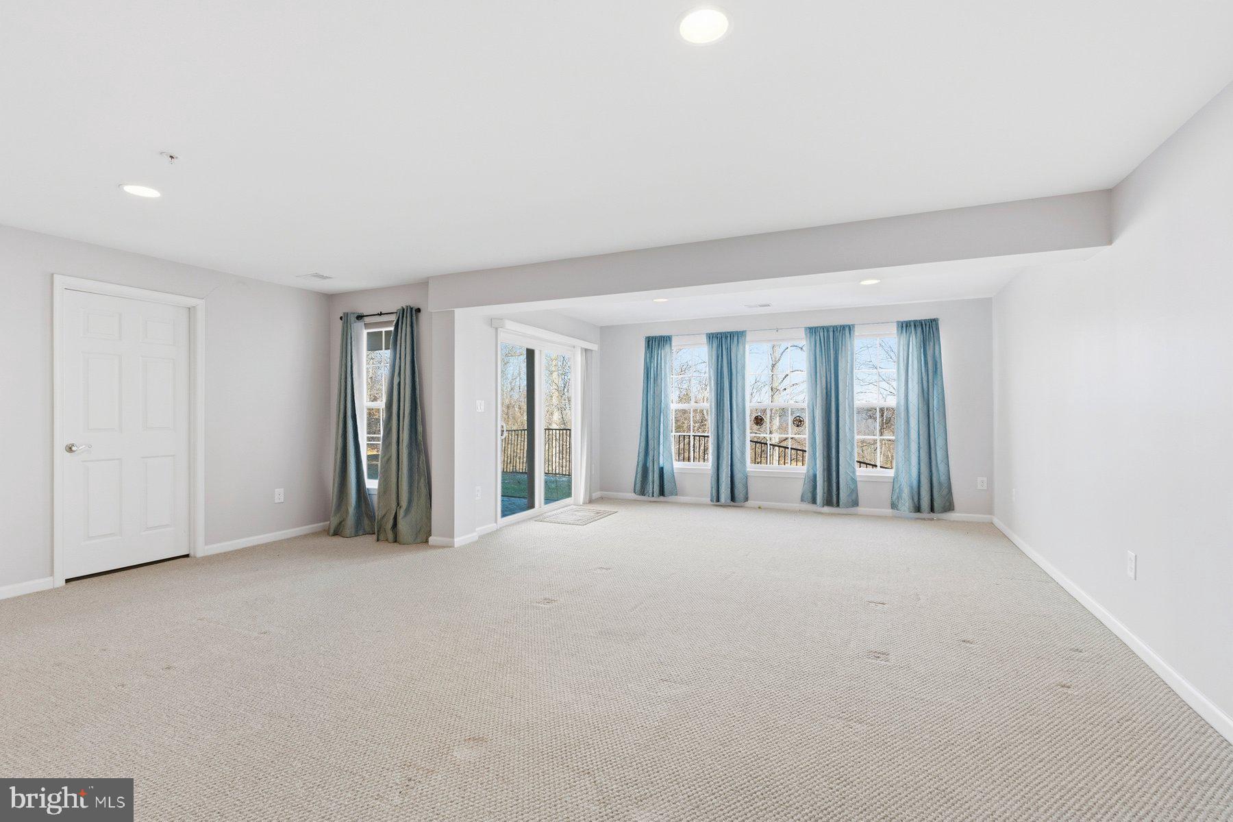 8330 Meadowsweet Road, Unit 8330 Pikesville, MD 21208 - Photo 37 of 55 a view of an empty room with wooden floor and a window
