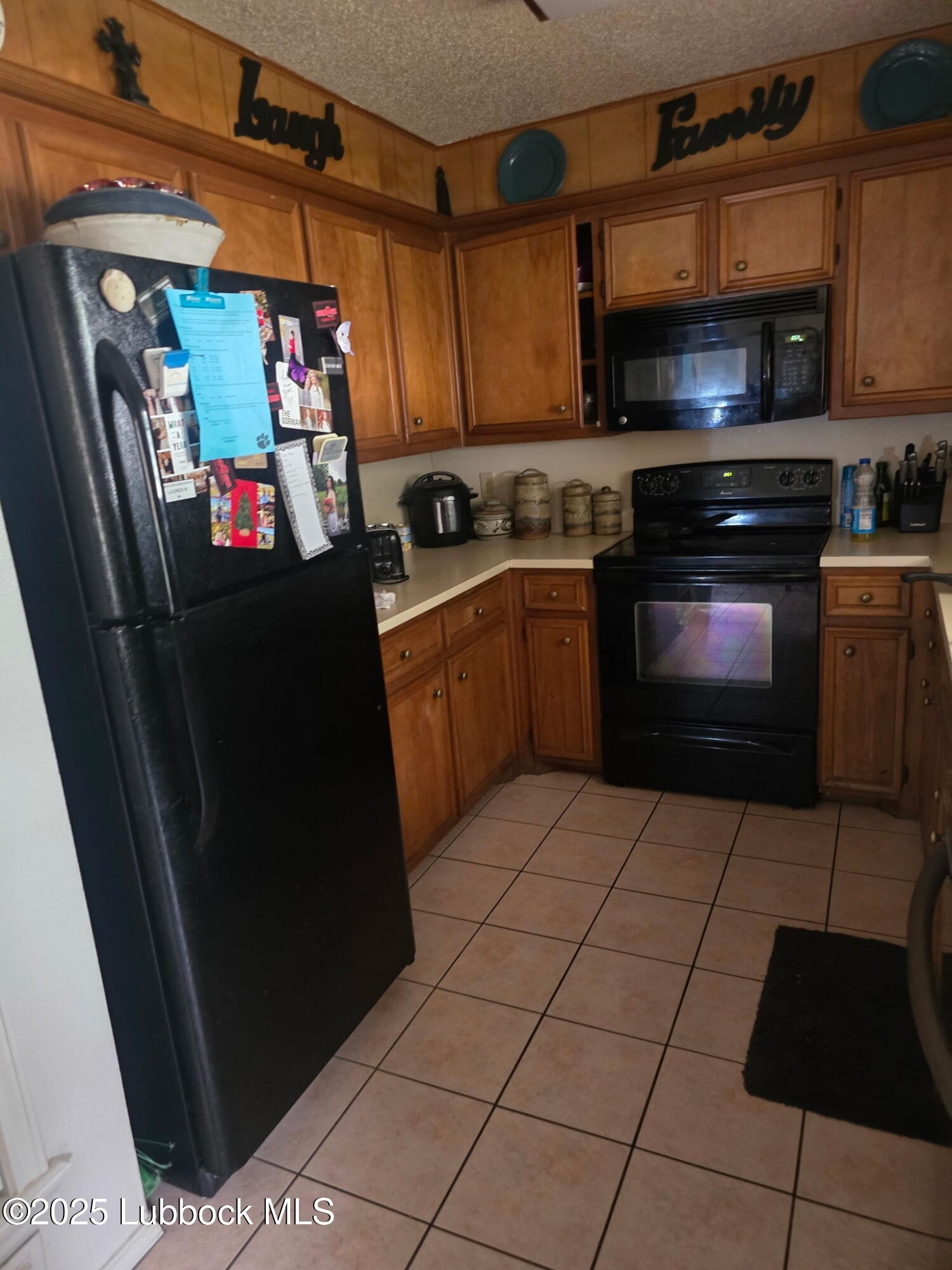 6004 68th Street Lubbock, TX 79424 - Photo 5 of 16 a kitchen with stainless steel appliances granite countertop a refrigerator and a stove top oven