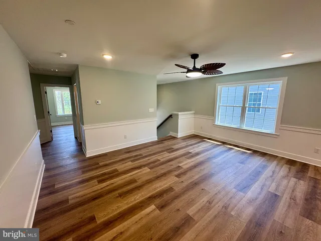 a view of a hallway with wooden floor and staircase