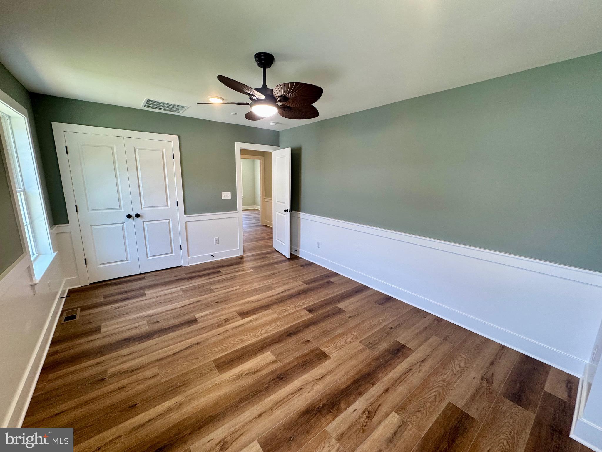 222 Long Point Road Stevensville, MD 21666 - Photo 21 of 44 a view of an empty room with wooden floor and a ceiling fan