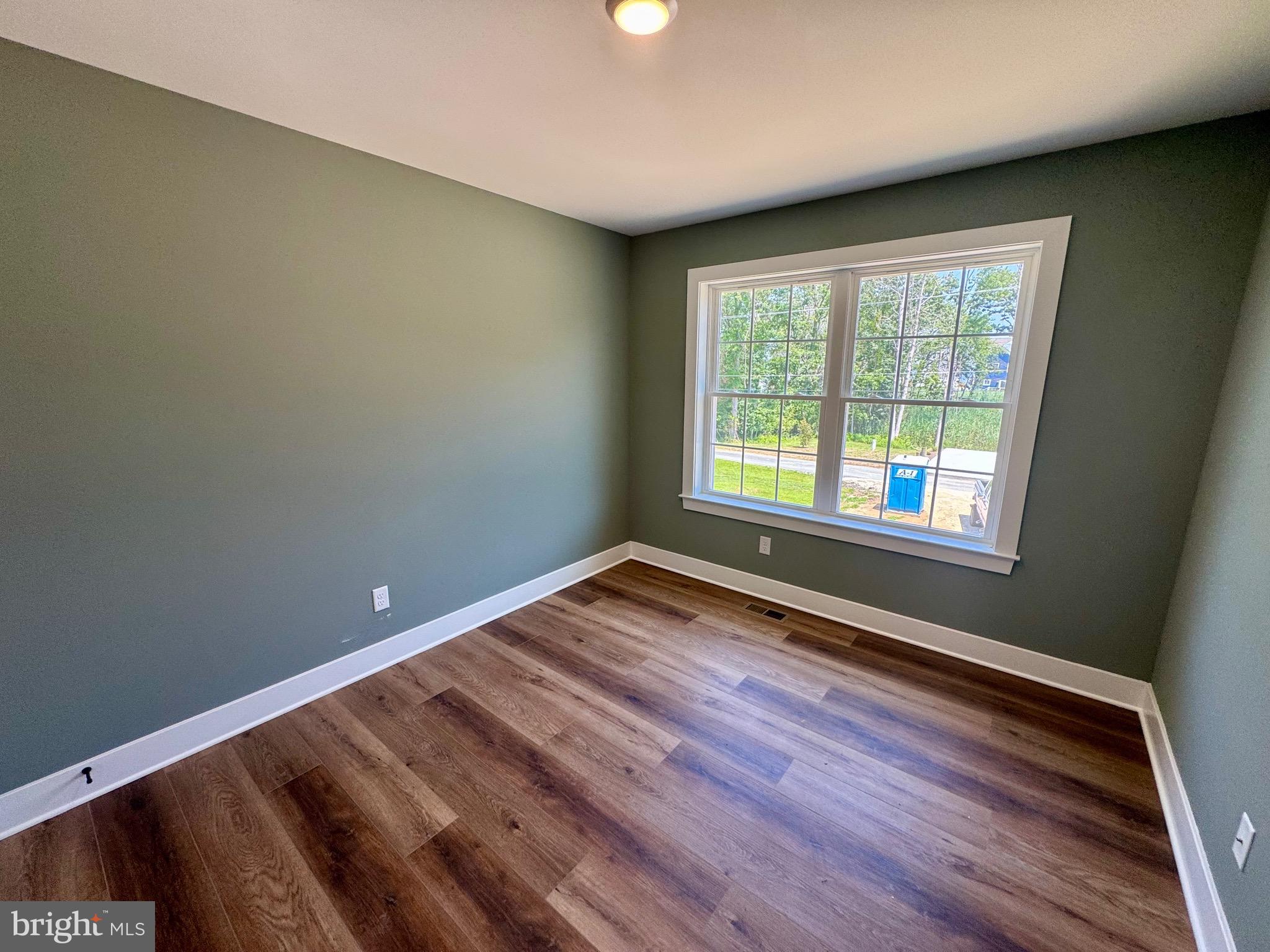 222 Long Point Road Stevensville, MD 21666 - Photo 22 of 44 a view of an empty room with wooden floor and a window