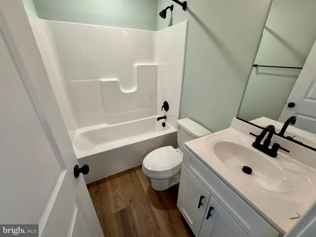 a view of a hallway with wooden floor and entryway