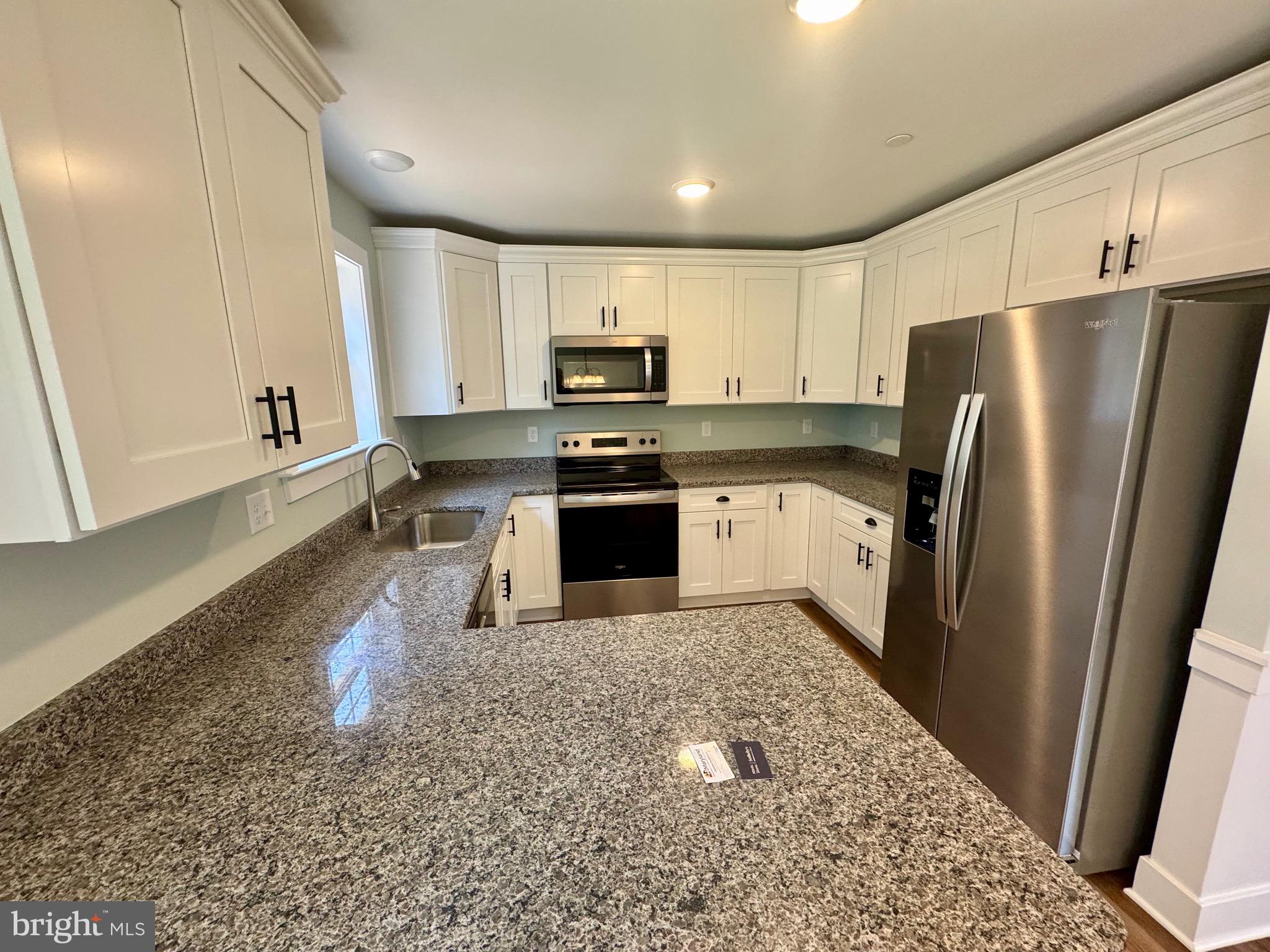222 Long Point Road Stevensville, MD 21666 - Photo 9 of 44 a kitchen with stainless steel appliances granite countertop a refrigerator a stove a sink and a microwave