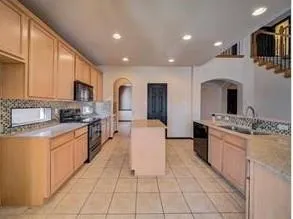a large kitchen with stainless steel appliances granite countertop a large stove top oven a sink dishwasher and granite countertops