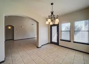 a view of a big room with windows and chandelier