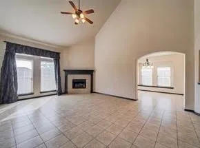 an empty room with windows and fireplace