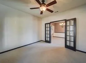 an empty room with windows and fan