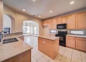 a kitchen with granite countertop a sink counter top space appliances and cabinets