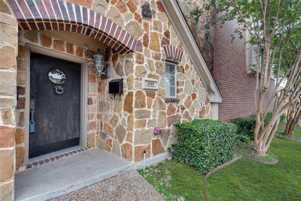 5102 Ridgedale Avenue Dallas, TX 75206 - Photo 23 of 27 Stone façade entryway featuring a dark wood-finish door with an oval window and decorative knocker