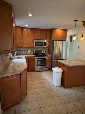 a kitchen with stainless steel appliances a stove a sink and a refrigerator