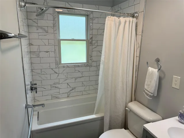a bathroom with a toilet and a shower
