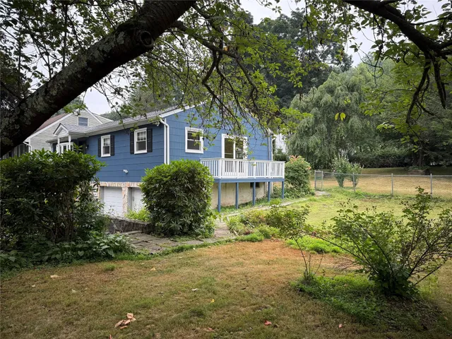 a house is sitting in middle of the green field