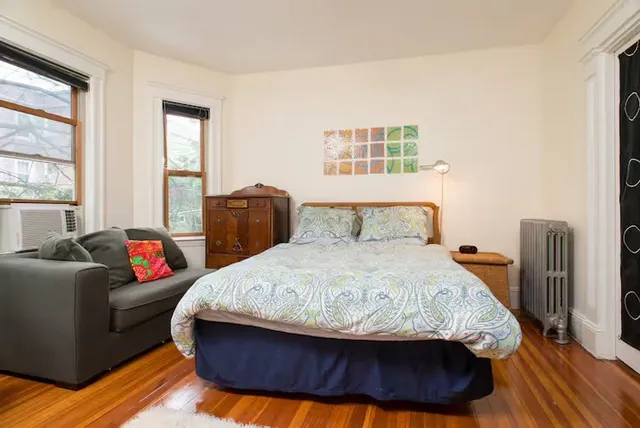 a bedroom with a bed and wooden floor