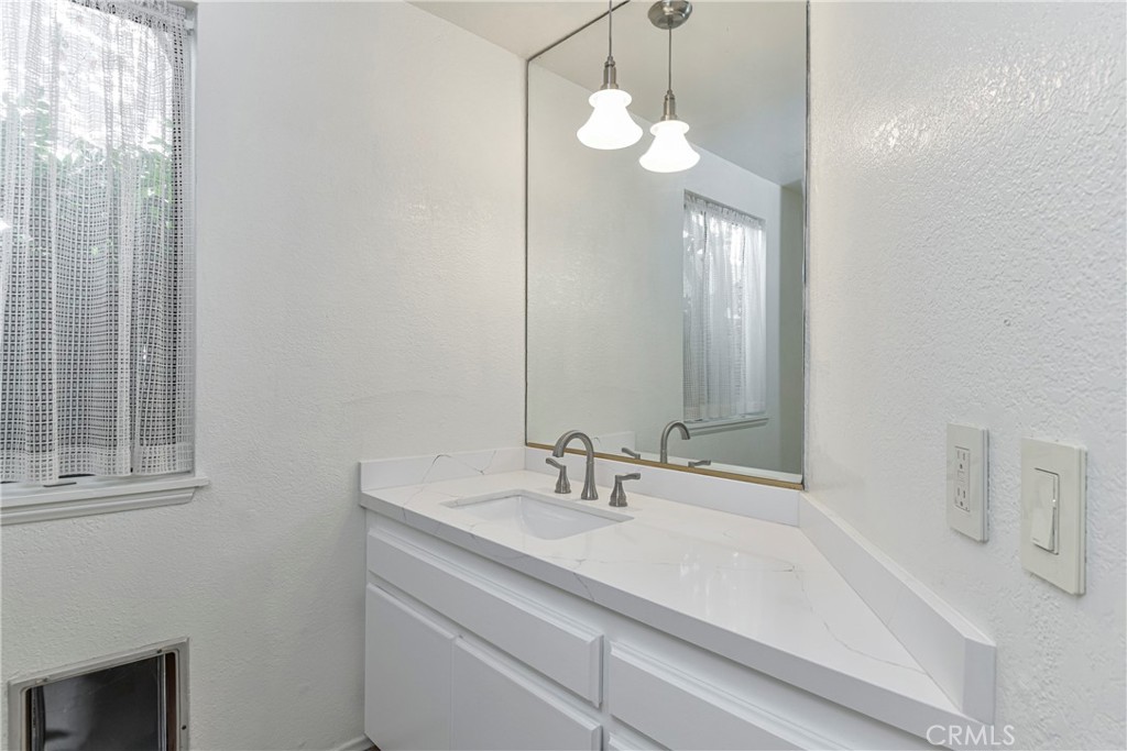 1141 17th Street, Unit 5 Santa Monica, CA 90403 - Photo 8 of 43 a bathroom with a sink a light fixture and a mirror