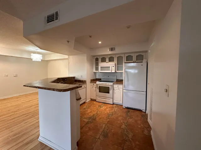 a kitchen with a sink a counter top space stainless steel appliances and cabinets