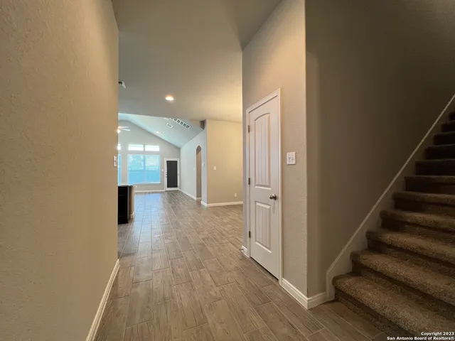 a view of a hallway with wooden floor and staircase