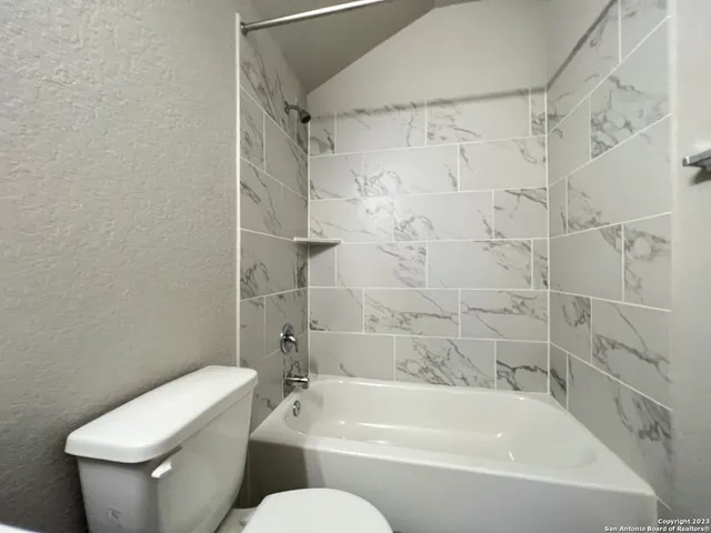 a white bath tub sitting next to a white toilet and sink