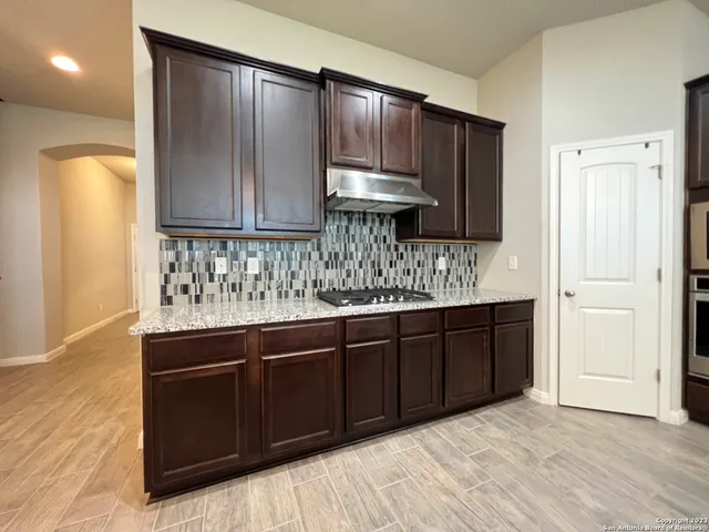 a kitchen with stainless steel appliances granite countertop a sink a stove and a refrigerator