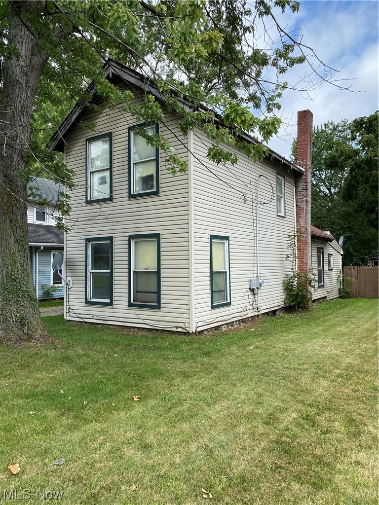 1309 West Prospect Road Ashtabula, OH 44004 - Photo 1 of 17 Rear view of house with a lawn