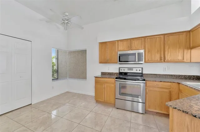 a kitchen with stainless steel appliances granite countertop a stove a sink and a microwave