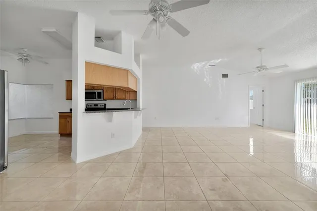 an empty room with windows and fan