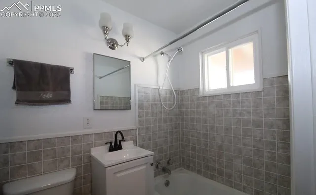 a bathroom with a sink toilet and window