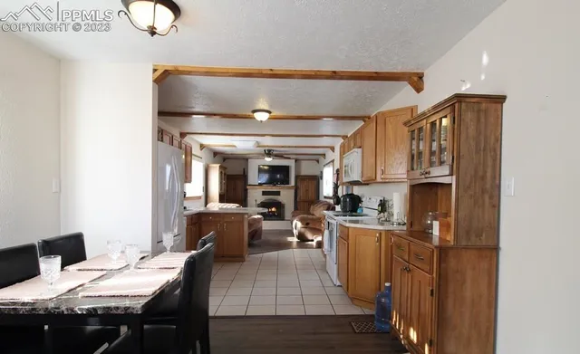 a kitchen with a dining table chairs and refrigerator