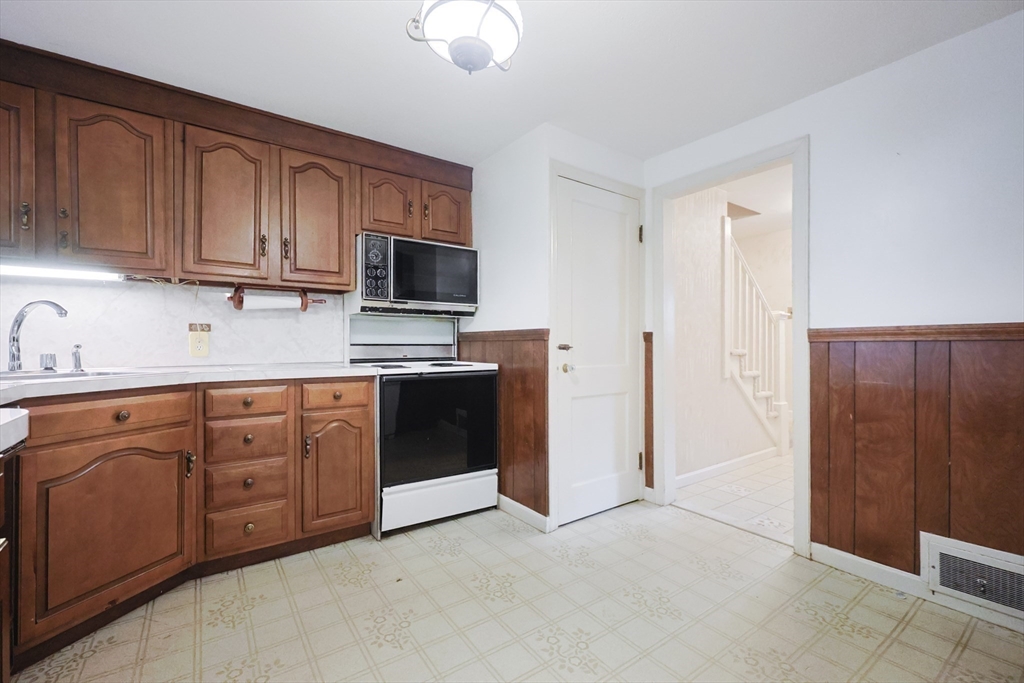 17 Sagamore Road Belmont, MA 02478 - Photo 6 of 35 a kitchen with stainless steel appliances granite countertop a stove a sink dishwasher and a refrigerator with wooden cabinets