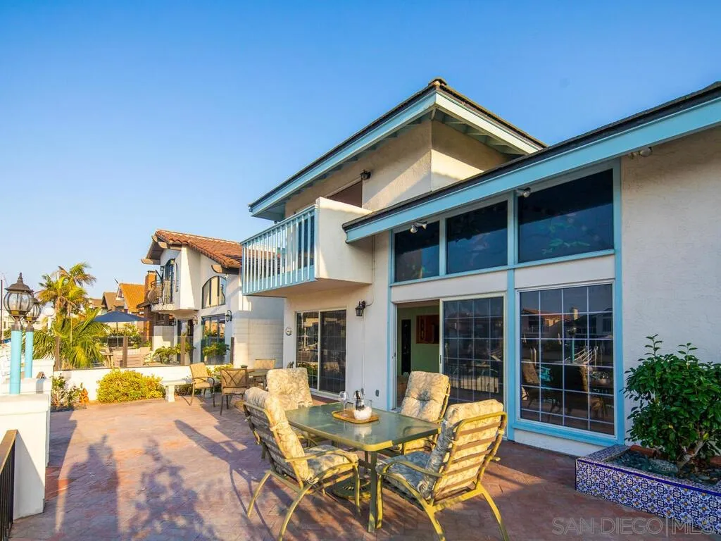 51 Green Turtle Road Coronado, CA 92118 - Photo 23 of 46 a front view of a house with a yard glass top table and chairs