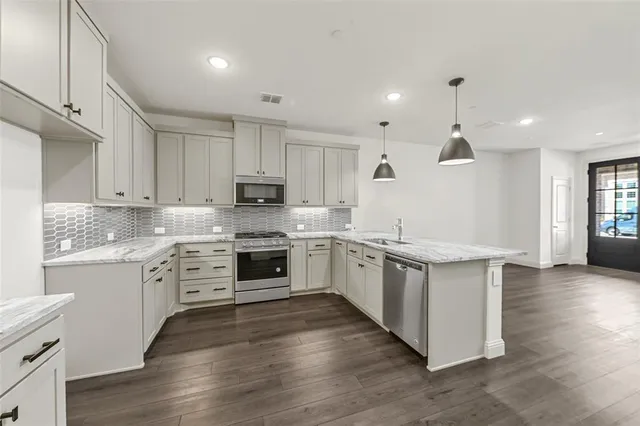 a kitchen with granite countertop white cabinets and white appliances