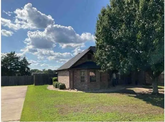 a view of a house with backyard and a tree