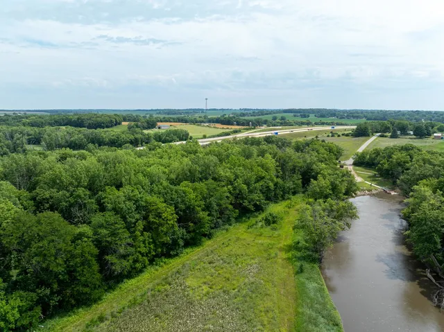 an aerial view of green landscape with trees houses and lake view