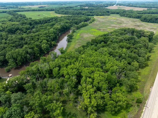 an aerial view of green landscape with trees houses and lake view