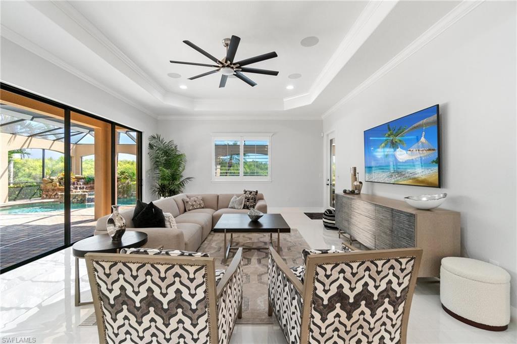 3440 Runaway Lane Naples, FL 34114 - Photo 12 of 42 Living area with a raised ceiling, ceiling fan, and ornamental molding