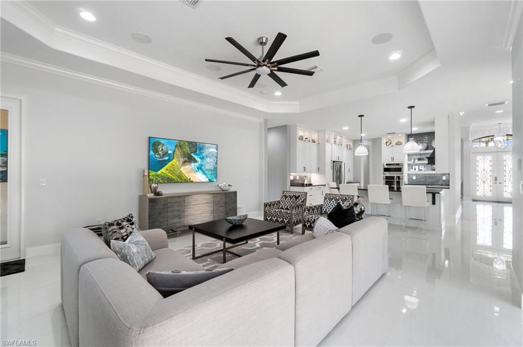 3440 Runaway Lane Naples, FL 34114 - Photo 13 of 42 Living room with a raised ceiling, a ceiling fan, recessed lighting, crown molding, and light marble finish flooring