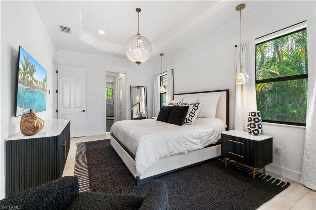 3440 Runaway Lane Naples, FL 34114 - Photo 16 of 42 Bedroom with multiple windows, ornamental molding, light wood finished floors, and a raised ceiling