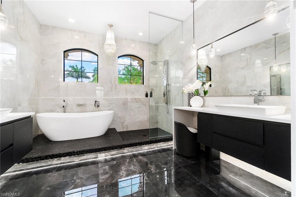3440 Runaway Lane Naples, FL 34114 - Photo 18 of 42 Bathroom featuring tile walls, marble tiled flooring, vanity, a soaking tub, and a tile shower