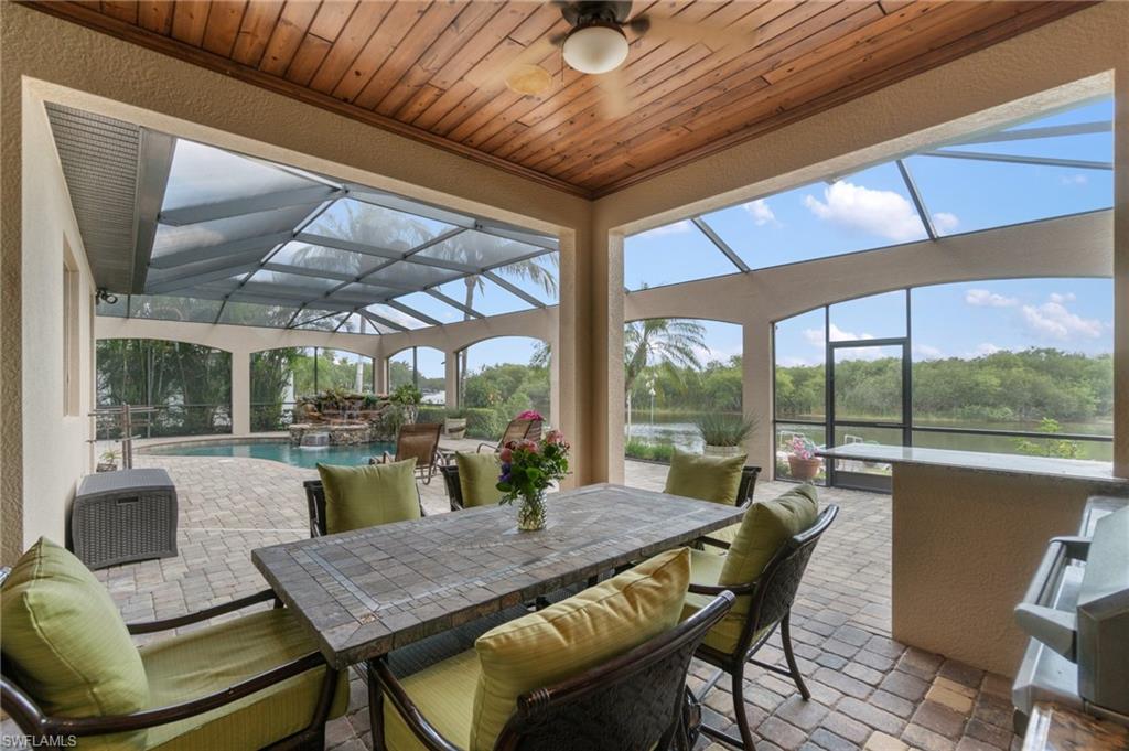 3440 Runaway Lane Naples, FL 34114 - Photo 29 of 42 Sunroom with a ceiling fan, outdoor dining space, a water view, and a swimming pool