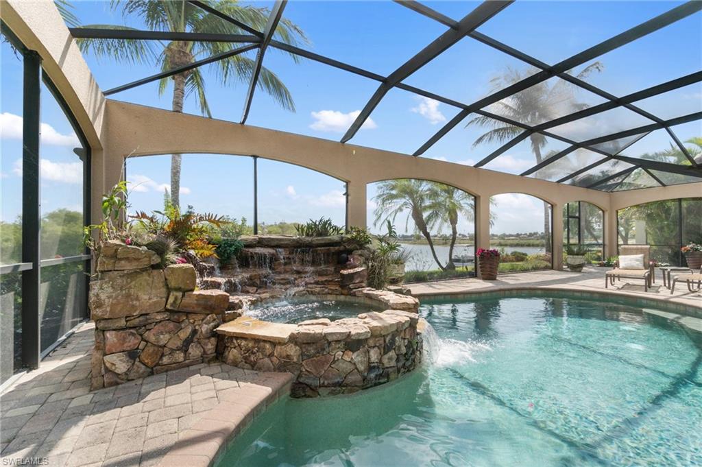 3440 Runaway Lane Naples, FL 34114 - Photo 33 of 42 View of swimming pool featuring glass enclosure, a patio, a pool with connected hot tub, and a water view