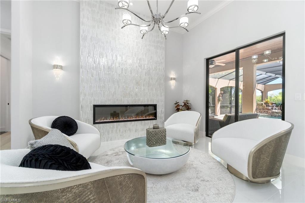 3440 Runaway Lane Naples, FL 34114 - Photo 4 of 42 Living room with a chandelier and a large fireplace