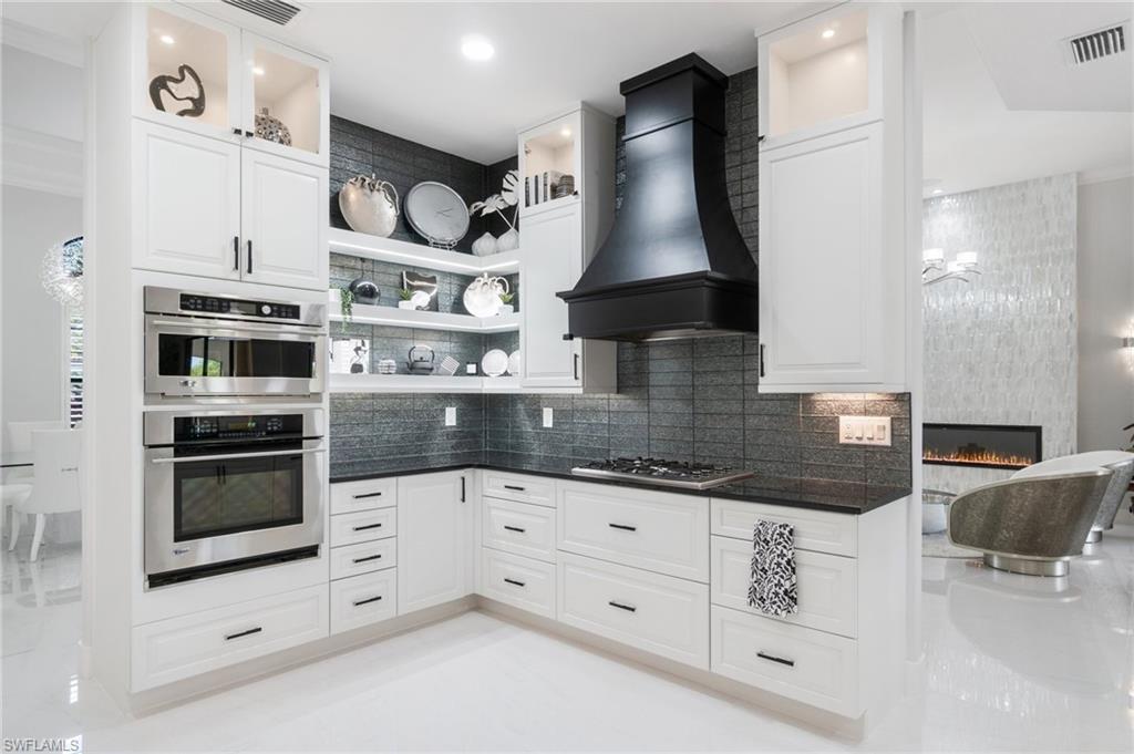 3440 Runaway Lane Naples, FL 34114 - Photo 10 of 42 Kitchen featuring premium range hood, open shelves, backsplash, and stainless steel gas stovetop