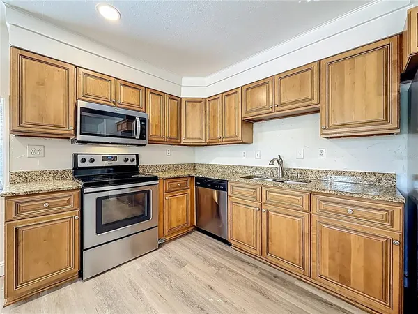 a large kitchen with wooden floors stainless steel appliances and cabinets