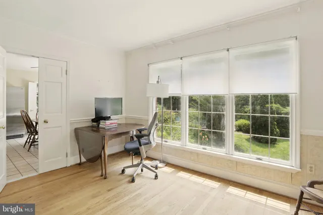 a view of a workspace with furniture and a window