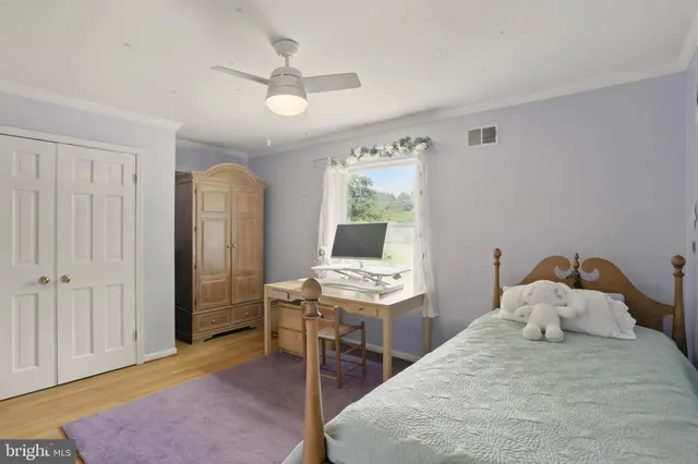 a bedroom with a bed and a computer on the desk