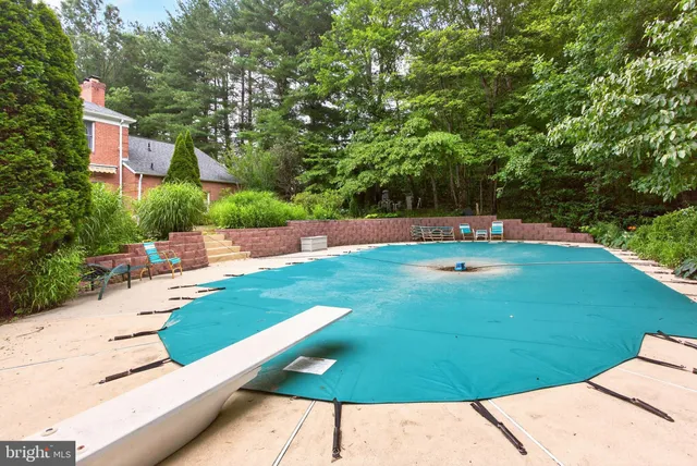 a view of a house with a yard and large tree