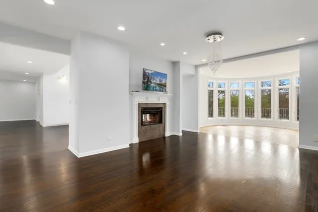 an empty room with wooden floor and a fireplace