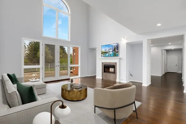 a view of an empty room with wooden floor and a fireplace