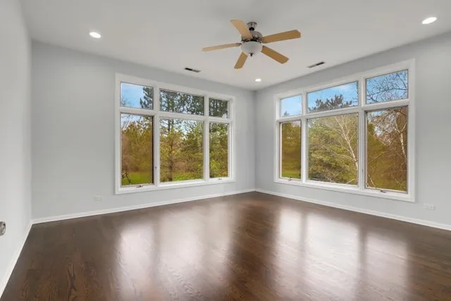 a view of empty room with wooden floor